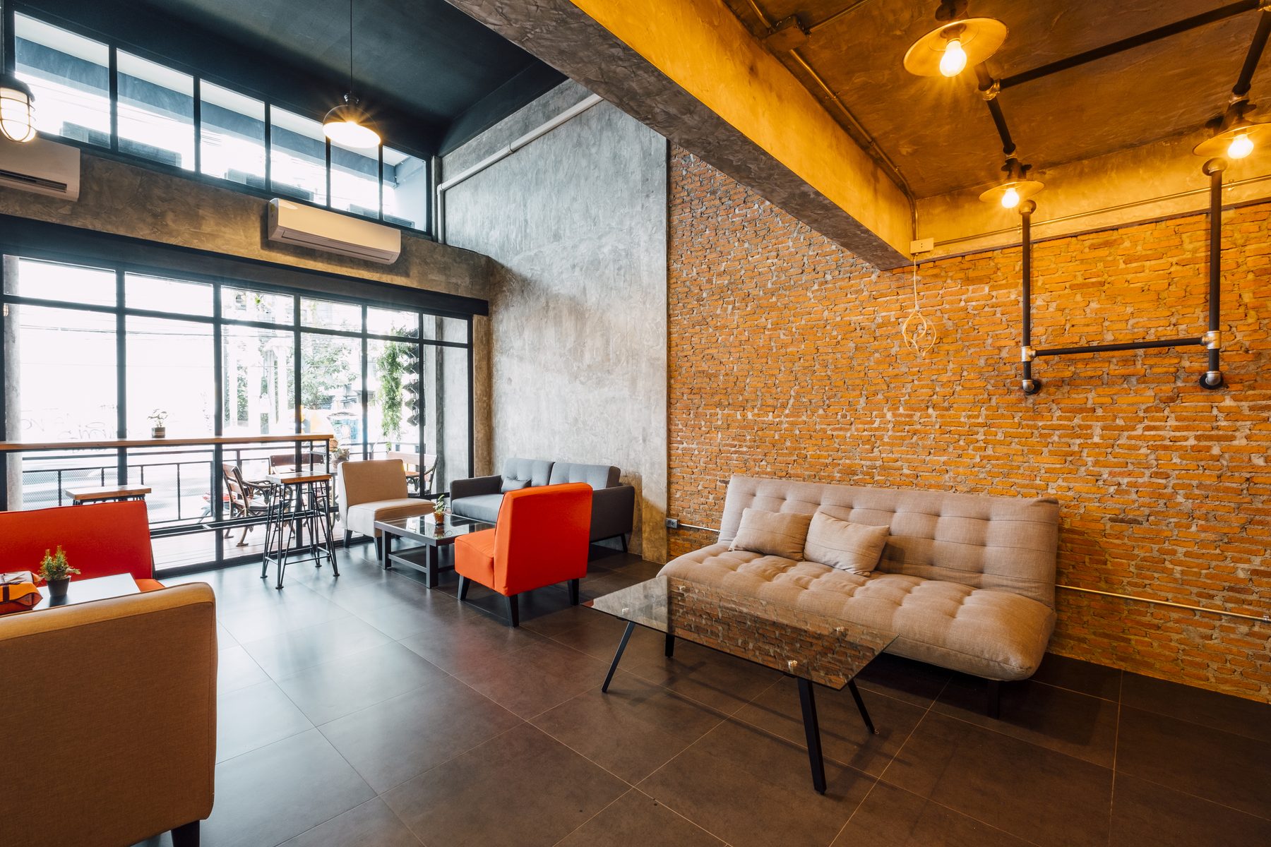 A converted warehouse cafe with exposed brick, concrete walls and warm filament lighting.